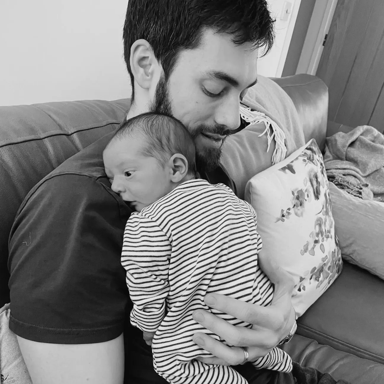 Black-and-white photo of me on a sofa, holding my newborn against my chest.